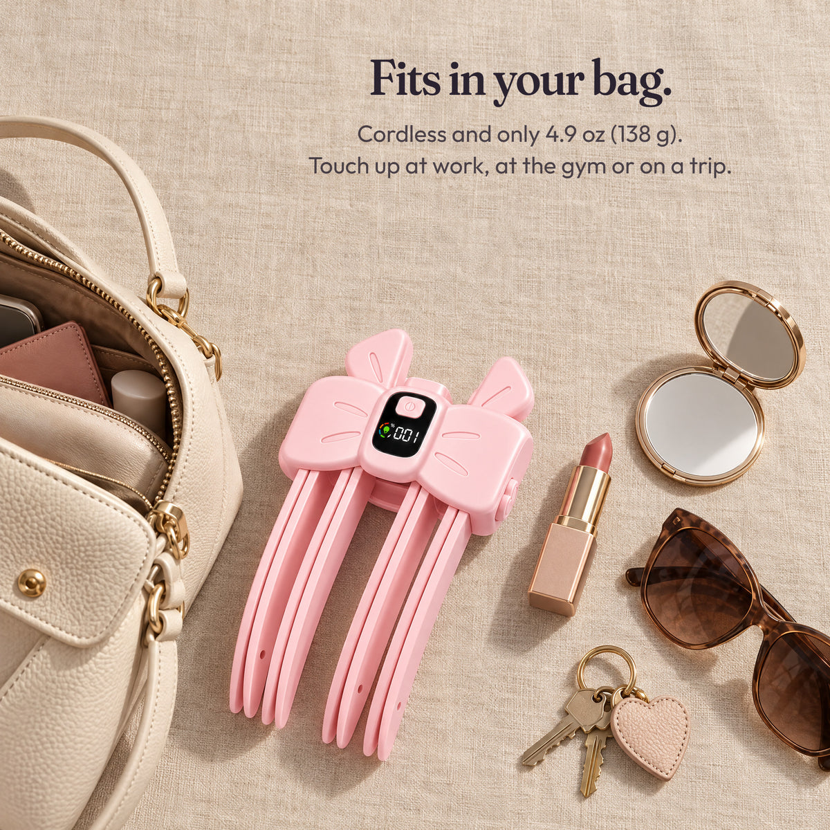 Pink AirTuft cordless root clip beside a handbag and everyday essentials