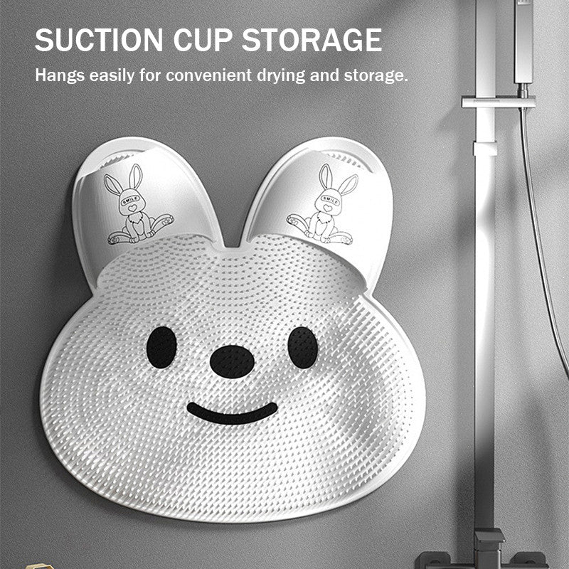 White ToeRub bunny foot brush hanging in a shower with suction cup storage